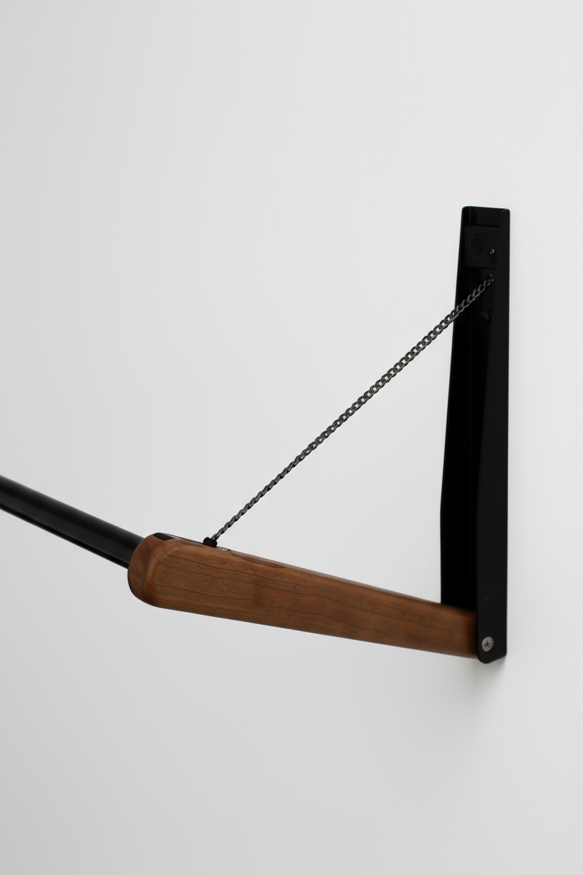 Close-up of FOLD.ONE wood lever and black wall mounts, showing stainless-steel support chain for smooth folding mechanism