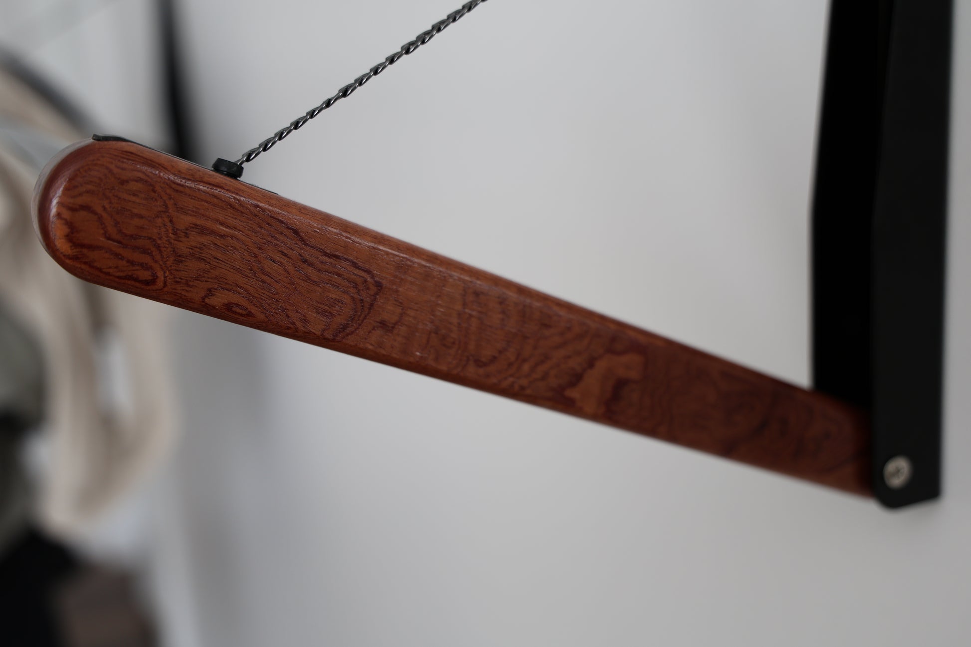 Detail of lacquered wood lever on FOLD.ONE rack in studio setting (Color: Wood Lover (Sapele))